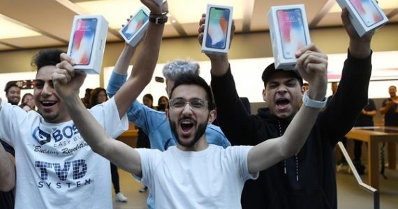 Mazen Kourouche, uno de los primeros compradores del iPhone X, muestra su adquisición junto a otros compradores durante el lanzamiento general al público del nuevo celular en una tienda Apple de la ciudad de Sydney (Australia) (EFE)