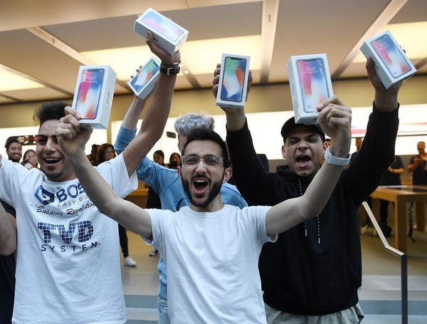 Mazen Kourouche, uno de los primeros compradores del iPhone X, muestra su adquisición junto a otros compradores durante el lanzamiento general al público del nuevo celular en una tienda Apple de la ciudad de Sydney (Australia) (EFE)